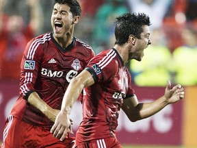 Toronto FC 's Andrew Wiedeman (right) celebrates scoring against New England Revolution as Toronto's Jonathan Osorio (left) looks on during first half MLS action in Toronto on Friday August 30, 2013. THE CANADIAN PRESS/Chris Young
