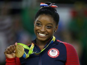 In this Aug. 16, 2016 file photo, United States gymnast Simone Biles displays her gold medal for floor during the artistic gymnastics women's apparatus final at the 2016 Summer Olympics in Rio de Janeiro, Brazil.