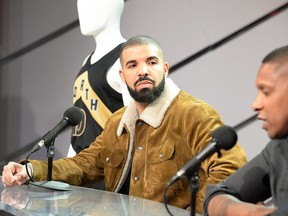 Canadian rap star Drake looks on as Toronto Raptors president Masai Ujiri speaks during a press conference where his OVO uniforms were unveiled ahead of NBA basketball action between the Toronto Raptors and Detroit Pistons in Toronto on Wednesday, January 17, 2018. THE CANADIAN PRESS/Frank Gunn