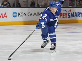 Travis Dermott of the Toronto Maple Leafs reaches for a loose puck against the Vancouver Canucks at the Air Canada Centre on Jan. 6, 2018