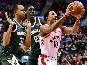 Toronto Raptors guard DeMar DeRozan drives between Milwaukee Bucks forward John Henson and Bucks guard Tony Snell on Jan. 1, 2018