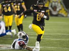 Hamilton Tiger-Cats quarterback Jeremiah Masoli (8) scrambles while chased by Montreal Alouettes defensive end John Bowman (7) during first half CFL football action in Hamilton, Ont., Friday, November 3, 2017. THE CANADIAN PRESS/Peter Power