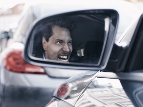 Driver with road rage reflected in wing mirror.