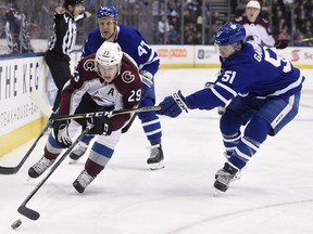 Colorado Avalanche centre Nathan MacKinnon (29) drives past Toronto Maple Leafs defenceman Jake Gardiner (51) as centre Leo Komarov (47) looks on during first period NHL hockey action in Toronto on Monday, January 22, 2018. THE CANADIAN PRESS/Nathan Denette