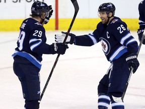Winnipeg Jets' Patrik Laine, Blake Wheeler and Kyle Connor celebrate after Laine scores during a game against the Vancouver Canucks on Jan. 21, 2018