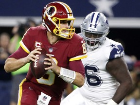 In this Thursday, Nov. 30, 2017, file photo, Washington Redskins quarterback Kirk Cousins (8) scrambles out of the pocket before throwing a pass under pressure from Dallas Cowboys' Maliek. (AP Photo/Michael Ainsworth, File)