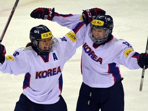 South Korea's Jo Su-Sie, left, celebrates with a teammate after scoring against North Korea during their IIHF women's world ice hockey championships division II group A competition match in Gangneung on April 6, 2017