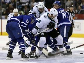 Toronto Maple Leafs and San Jose Sharks players battle for a loose puck at centre on Jan. 4, 2018