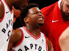 Toronto Raptors guard Kyle Lowry reacts as he is helped off by teammates during the second half of an NBA basketball game against the Brooklyn Nets on Jan. 8, 2018