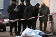 Italian cops stand over the body of a dead Naples gangster. A crackdown has resulted in more than 160 arrests revealing breakthtaking corruption.
