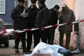 Italian cops stand over the body of a dead Naples gangster. A crackdown has resulted in more than 160 arrests revealing breakthtaking corruption.