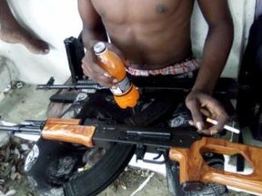 A Montego Bay gangbanger cradles his AK-47. The government is urging Canadians to exercise extreme caution in Jamaica due to widespread violence that has resulted in a state of emergency.