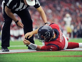 In this Dec. 10, 2017, file photo, Houston Texans quarterback Tom Savage is checked by a referee after he was hit during the first half of an NFL football game against the San Francisco 49ers