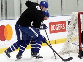 Maple Leafs defenceman Nikita Zaitsev fights for the puck with Zach Hyman during practice at the MCC on Wednesday in Toronto. (Jack Boland/Toronto Sun)