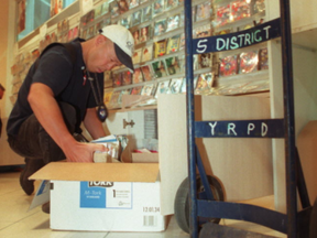 A York Region Police officer loads counterfeit CDs into a box after a 2005 raid on the Pacific Mall flea market at Kennedy Rd. and Steeles Ave.