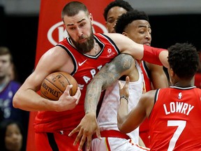 Toronto Raptors' Jonas Valanciunas grabs a rebound from Atlanta Hawks' John Collins on Jan. 24, 2018