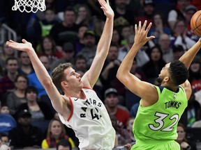 Minnesota Timberwolves' Karl-Anthony Towns, right, shoots as Toronto Raptors' Jakob Poeltl defends during the second half of an NBA basketball game Saturday, Jan. 20, 2018, in Minneapolis. The Timberwolves won 115-109. The Associated Press