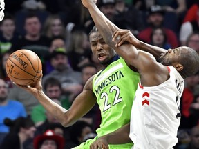 Minnesota Timberwolves' Andrew Wiggins, left, and Toronto Raptors' Serge Ibaka get wrapped up during the second half of an NBA basketball game Saturday, Jan. 20, 2018, in Minneapolis. The Timberwolves won 115-109. The Associated Press