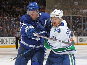 Maple Leafs defenceman Morgan Rielly (left) battles Daniel Sedin of the Vancouver Canucks on Saturday night at the Air Canada Centre. (Claus Andersen/Getty Images)