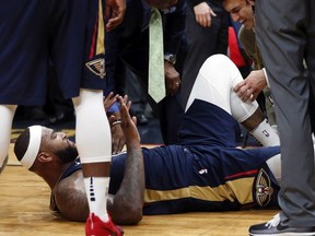 New Orleans Pelicans center DeMarcus Cousins lies on the court while being tended to after injuring his left Achilles tendon, according to the team, during the second half of the team's NBA basketball game against the Houston Rockets in New Orleans, Friday, Jan. 26, 2018. The Pelicans won 115-113.