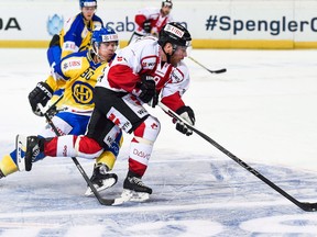 Team Canada's Derek Roy, right, fights for the puck with Davos' Sven Jung, during the game between Team Canada and Switzerland's HC Davos at the Spengler Cup on Dec. 28, 2015