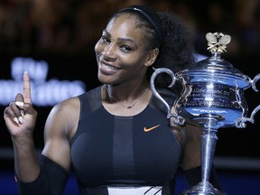 In this Jan. 28, 2017, file photo, Serena Williams holds up a finger and her trophy after defeating her sister, Venus, in the women's singles final at the Australian Open tennis championships in Melbourne.