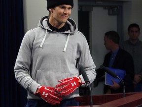 New England Patriots quarterback Tom Brady wears gloves as he arrives to speak to the media, Friday, Jan. 19, 2018, in Foxborough, Mass. (AP Photo/Bill Sikes)