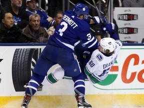 Defenceman Travis Dermott, playing in his first regular-season game for the Maple Leafs, lays out Canucks forward Markus Granlund at the Air Canada Centre on Saturday night. Dermott had an assist and was plus-1 in 12:03 of ice time. (Dave Abel/Toronto Sun)