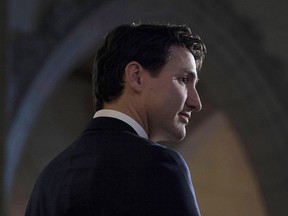 Prime Minister Justin Trudeau listens to a question from the media in the foyer of the House of Commons following the release of an ethics report in Ottawa on December 20, 2017.