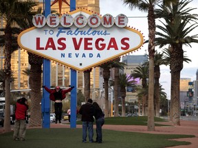 In this Feb. 12, 2009, file photo, tourists take pictures in front of the Las Vegas welcome sign.