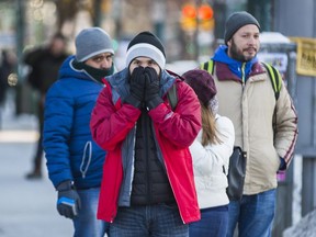 A pedestrian braces against the cold at the intersection of Queen St. W and Spadina Ave. in Toronto, Ont.  on Saturday January 6, 2018. Ernest Doroszuk/Toronto Sun/Postmedia Network