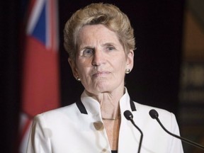 Ontario Premier Kathleen Wynne talks to media at the Confederation of Tomorrow 2.0 Conference in Toronto on Tuesday December 12, 2017. The premier of Ontario is accusing the children of Tim Hortons' billionaire co-founders of bullying their employees by reducing their benefits in response to the province's increased minimum wage.