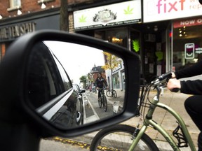 Cyclists ride on the designated Bloor Street bike lanes in Toronto on  Oct. 12, 2017. (THE CANADIAN PRESS)