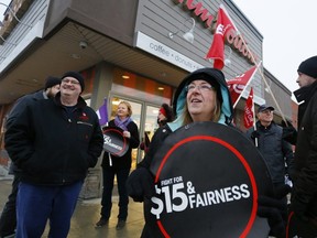 Protesters gather outside the Tim Hortons store on Monaghan Rd. on Wednesday Jan. 10, 2018 in Peterborough, Ont. demanding that the corporation not roll back workers wages and benefits. (Postmedia Network)