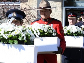 Police carry caskets containing the remains of four infants. (DAVE ABEL, Toronto Sun)