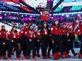 Team Canada — including ice dancer Piper Gilles on the shoulders of partner Paul Poirier and ski-cross racers Brittany Phelan, Kelsey Serwa and Marielle Thompson — walks in the parade of athletes during the closing ceremony of the PyeongChang 2018 Winter Olympic Games on Feb. 25, 2018.