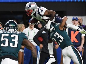 Brandin Cooks (C) of the New Enlgand Patriots attempts unsuccessfully to hurdle over Rodney McLeod (R) of the Philadelphia Eagles during Super Bowl LII at US Bank Stadium in Minneapolis, Minnesota, on February 4, 2018. / AFP PHOTO / TIMOTHY A. CLARYTIMOTHY A. CLARY/AFP/Getty Images