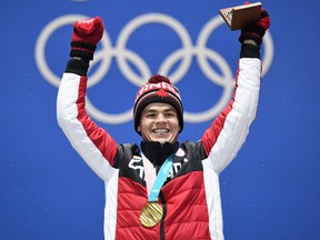 Mikael Kingsbury celebrates with his gold medal on the Olympic moguls podium on Feb. 13.