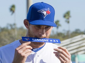 Toronto Blue Jays pitcher Joe Biagini holds his name tag in his mouth on photo day at spring training in Dunedin, Fla. on Thursday February 22, 2018. (THE CANADIAN PRESS/Frank Gunn)