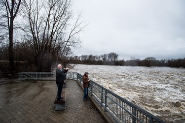 Brantford residents photograph rushing water on the Grand River at the Wilkes Dam. Residents were being evacuated due to flooding after an ice jam upstream of Parkhill Dam sent a surge of water downstream on Wednesday, February 21, 2018. THE CANADIAN PRESS/Aaron Vincent Elkaim