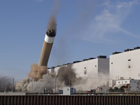 The west stack starts to fall at Ontario Power Generation's former coal-fired Nanticoke Generating Station at 11:00 a.m on Wednesday February 28, 2018 in Nanticoke, Ontario moments after numerous booming blasts could be heard from dynamite placed by crews from Delsan-AIM Environmental Services. (Brian Thompson/Postmedia Network)