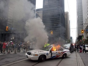 A police car burns after G20 summit protesters set fire to it in downtown Toronto on Saturday, June 26, 2010.