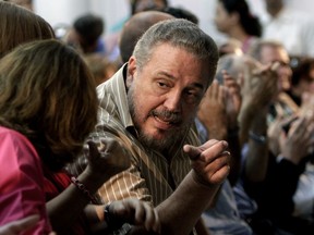 In this March 14, 2012 file photo, Fidel Castro Diaz-Balart, son of then Cuban leader Fidel Castro, speaks with an unidentified woman during the presentation of his father's book "Nuestro Deber es Luchar," or "Our Duty is to Fight," in Havana, Cuba. According to Cuban state media on Feb. 1, 2018, Diaz-Balart has killed himself.