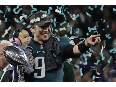 Philadelphia Eagles quarterback Nick Foles (9) holds his daughter, Lily James, after winning the NFL Super Bowl 52 football game against the New England Patriots, Sunday, Feb. 4, 2018, in Minneapolis. The Eagles won 41-33.