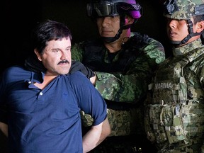 In this Jan. 8, 2016 file photo, a handcuffed Joaquin "El Chapo" Guzman is made to face the press as he is escorted to a helicopter by Mexican soldiers and marines at a federal hangar in Mexico City. (AP Photo/Eduardo Verdugo, File)