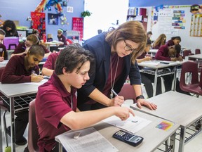 Teacher Nathalie Gilbert along with grade 7 student Caleb Piette during math class at School Secondary Catholic Saint-Charles-Garnier in Whitby, Ont. on Thursday February 15, 2018. School Secondary Catholic Saint-Charles-Garnier is the top improving school in the GTA in this year's Fraser Institute Secondary School Report Card.