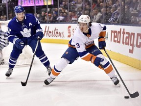 New York Islanders centre Mathew Barzal (13) shields the puck from Toronto Maple Leafs centre Tyler Bozak (42) during first period NHL hockey action in Toronto on Wednesday, January 31, 2018. THE CANADIAN PRESS/Frank Gunn ORG XMIT: FNG502