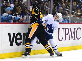 Zach Hyman of the Toronto Maple Leafs checks Ian Cole of the Pittsburgh Penguins into the glass at PPG PAINTS Arena on Feb. 17, 2018