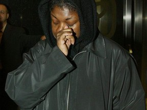 Marcia Dooley wipes her face as she leaves University Ave. court after the jury had adjourned for the night in Toronto, Tuesday, April 16, 2002. Tony Dooley and wife Marcia are accused of killing Randal Dooley.