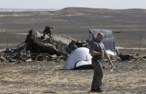 A Russian investigator walks near wreckage a day after a passenger jet bound for St. Petersburg, Russia, crashed in Hassana, Egypt, on Sunday, Nov. 1, 2015. (AP Photo/Amr Nabil)
